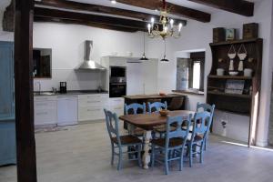 a kitchen with a wooden table and blue chairs at Casa Rural Estrella del Sil in Corbón del Sil