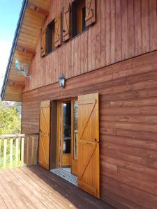 un edificio in legno con porte sul lato di Chalet montagnard Perce Neige avec terrasse plein sud-5 personnes a Murat-le-Quaire Altre 9 foto