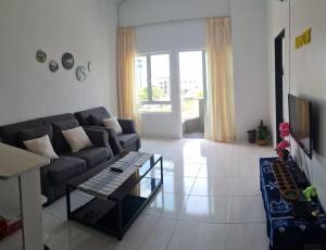 uma sala de estar com um sofá e uma mesa em Full Moon Apartment (月满公寓）网红 airbnb em Kuah