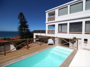 a house with a swimming pool on a balcony at Surfstar at Mimosa Jeffreys Bay in Jeffreys Bay
