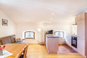 een keuken en een woonkamer met een houten tafel bij Ferienwohnung Talblick in Jachenau