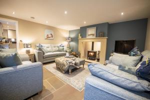 a living room with three couches and a fireplace at Beckside in West Burton