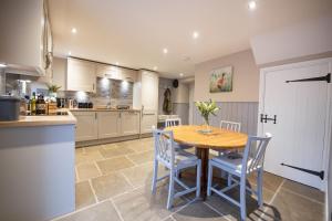 a kitchen with a wooden table and blue chairs at Beckside in West Burton