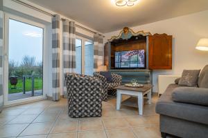 a living room with a couch and a table at Wildrose EG (2) in Archsum