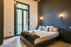 ein Schlafzimmer mit einem großen Bett und einem großen Fenster in der Unterkunft Midtown Luxury Apartments by Sweett in Barcelona + 14 Fotos