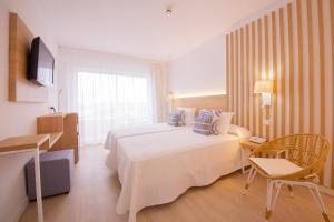 a hotel room with a large bed and a television at Hotel Cala Font in Salou