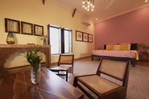 a living room with a table and chairs and a bed at Kaner Retreat - India's First Desert Botanical Resort in Shaitrāwa