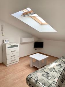 sypialnia z łóżkiem, oknem dachowym i stołem w obiekcie Apartments Happy Stay Center Baska w Bašce