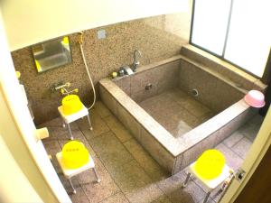 an overhead view of a bathroom with a tub and two chairs at YADO OMIYA / Vacation STAY 45672 in Kamogawa