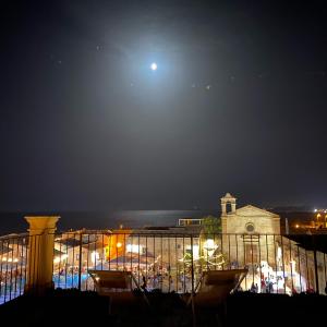 a view of the moon over a city at night at Regina Margherita B&B in Marzamemi