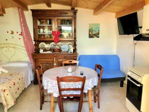 a dining room with a table and a blue couch at Il Giardino Degli Angeli in Presicce