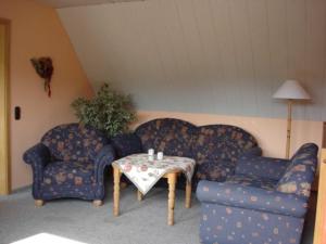 Una sala de estar con dos sofás azules y una mesa. en Dat hyggelige Ferienhus in Kappeln, en Kappeln