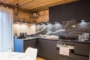 a kitchen with black cabinets and a counter top at Paccard Locations Chamonix in Chamonix-Mont-Blanc