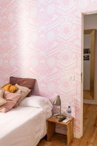 a bedroom with a bed and a pink and white wall at Mapango Small Rooms in Santa Cruz de Tenerife
