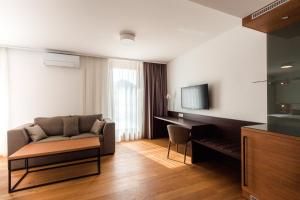 a living room with a couch and a desk at Hotel Ajdovec in Sevnica