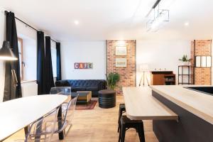 a living room with a table and chairs and a couch at L'atelier de Nicolas - Bel appt au cœur de Nancy in Nancy