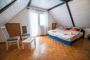 a bedroom with a bed and a chair in a attic at Apartment Tina with Seasonal Pool in Podsreda