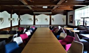 einen großen langen Tisch in einem Zimmer mit Stühlen in der Unterkunft Dreispitz -B&B-Hotel Garni in Hofheim am Taunus