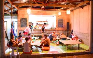 grupa ludzi siedzących przy stolikach w restauracji w obiekcie Malapascua Budget Inn MBI DIVE CENTER w mieście Wyspa Malapascua