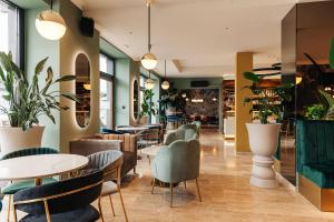 a restaurant with tables and chairs and plants at Hotel Ajdovec in Sevnica