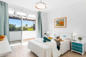 a white bedroom with a bed and a large window at Las Vistas Cristianos by Welcome Tenerife in Los Cristianos +34 photos