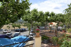 un balcón con un árbol y un aparcamiento en Hotellerie de l'Esplanade, en Rians