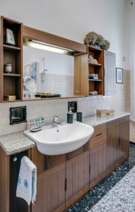 ein Badezimmer mit einem Waschbecken und einem großen Spiegel in der Unterkunft Sentirsi a casa, lontano da casa-feel at home away from home in Caronno Pertusella