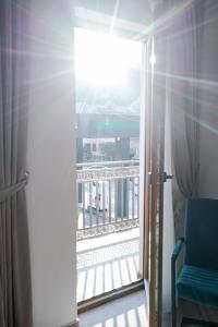 an open door to a balcony with a blue chair at Pensiunea Gamas in Putna