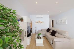 a white living room with a couch and a table at Villa Porto Colom Select in Portocolom