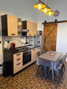 a kitchen with a table and a stove and a table and chairs at TheRoom in Catania