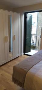 a bedroom with a bed and a sliding glass door at Estudio Casco Vello in Vigo