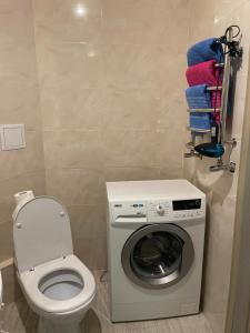 a bathroom with a toilet and a washing machine at 050 Уютные апартаменты ЖК «Софиевская Слободка» in Vyshneve