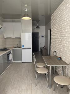 a kitchen with a table and chairs and a white refrigerator at 050 Уютные апартаменты ЖК «Софиевская Слободка» in Vyshneve