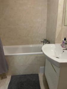 a bathroom with a sink and a bath tub next to a white sink at 050 Уютные апартаменты ЖК «Софиевская Слободка» in Vyshneve