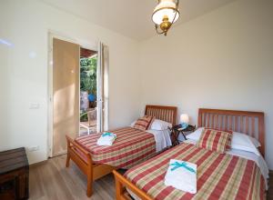 two beds in a room with a window at La Pavona Villa Luxury Collection in Monterosso al Mare