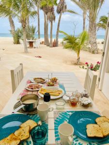 einen Tisch mit Teller mit Speisen am Strand in der Unterkunft Villa Nº 25 Alfredo Marchetti Suites on the Beach,Praia de Chaves BV in Cabeçadas