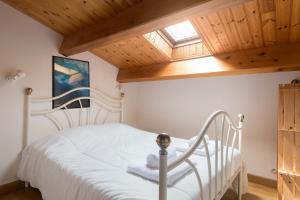 ラ・フロットにあるMaison Trémiereの木製の天井のベッドルーム1室(白いベッド1台付)