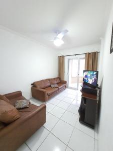 a living room with a couch and a tv at Max House PG -Novo, 82m2, Guilhermina, Churrasqueira e prox a feirinha in Praia Grande