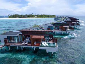 een groep huizen in het water in de oceaan bij Park Hyatt Maldives Hadahaa in Gaafu Alifu Atol