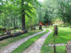 a stone path in a park with trees at Cabañas de Madera Sanabria in Vigo de Sanabria