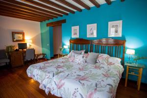 um quarto com uma cama e uma parede azul em Hotel Casa Palacio Uclés em Uclés