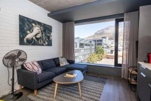 salon z niebieską kanapą i dużym oknem w obiekcie 514 Wex1 Modern Studio Apartment w Kapsztadzie