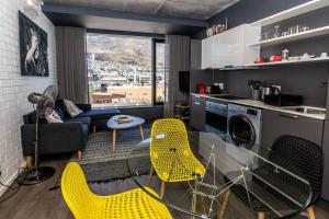 salon ze szklanym stołem i żółtymi krzesłami w obiekcie 514 Wex1 Modern Studio Apartment w Kapsztadzie