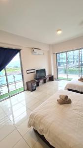 a bedroom with a large bed and a flat screen tv at Aeropod KK Corner Unit Near City and Airport 4 pax Free Parking in Kota Kinabalu