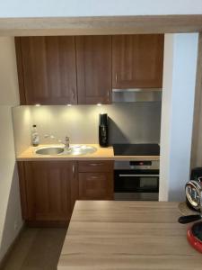 a kitchen with a sink and a stove at Zongerichte studio Sint-Idesbald met mooi zeezicht in Koksijde +11 photos