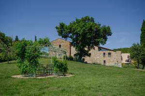 a table and chairs in a field in front of a building at Podere Carceroni in Cinigiano