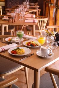 a wooden table with plates of food and drinks on it at S&atilde;o Vicente Alfama Hotel by TRIUS Hotels in Lisbon