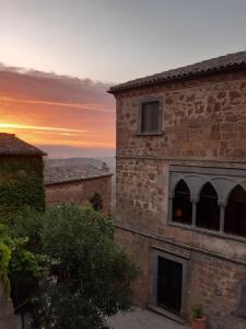 a sunset view of a brick building with the sunset in the background at Il Vento e la Ginestra in Bagnoregio