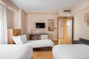 a hotel room with two beds and a couch at Crisol Almirante Bonifaz in Burgos