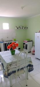 a kitchen with a table and chairs with flowers on it at Flats Xingó in Piranhas